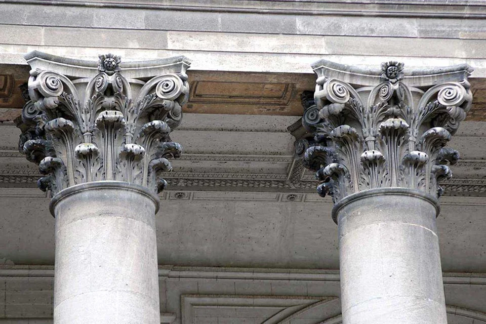 Deux colonnes de pierre avec chapiteaux corinthiens sculptés.