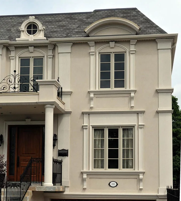Façade avec pilastres, encadrements de fenêtres et porte cintrée.