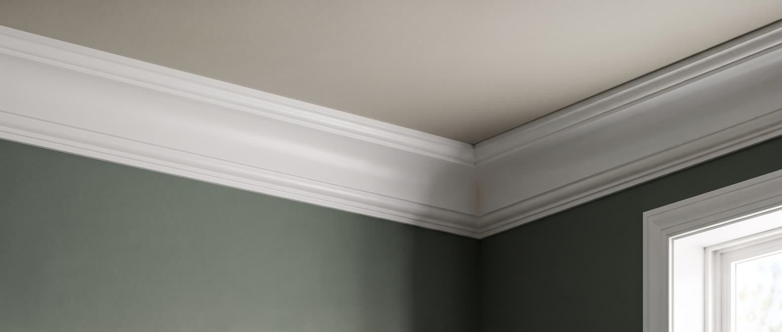 White One Step Cove crown moulding in the corner of a room, standing out against a deep green wall and a warm ceiling
